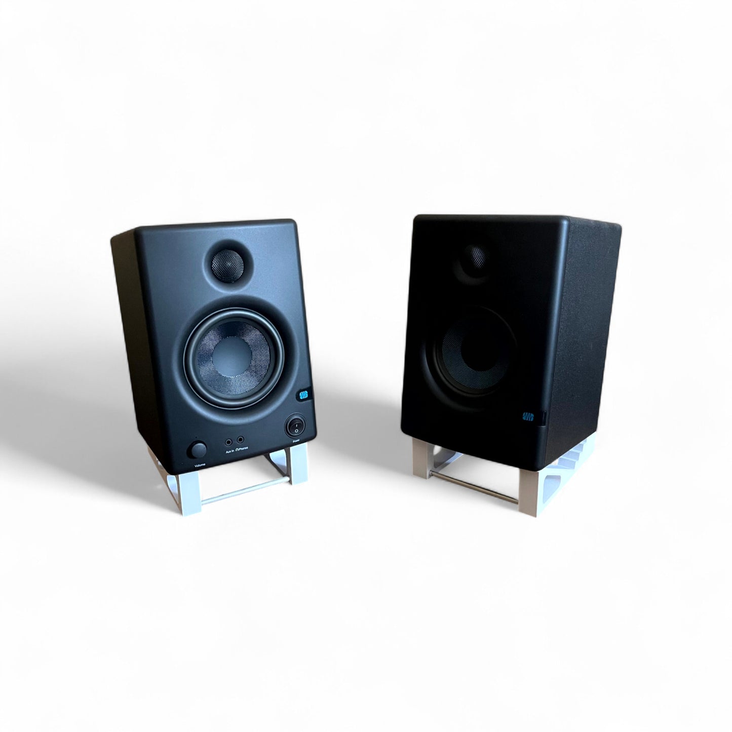 A pair of 3D printed Presonus Eris E4.5 Studio Speaker / Monitor 0 - 24 degree stands holding a pair of Presonus Eris 4.5 speakers, by Cold Earth Industries. Shown in white on a white background