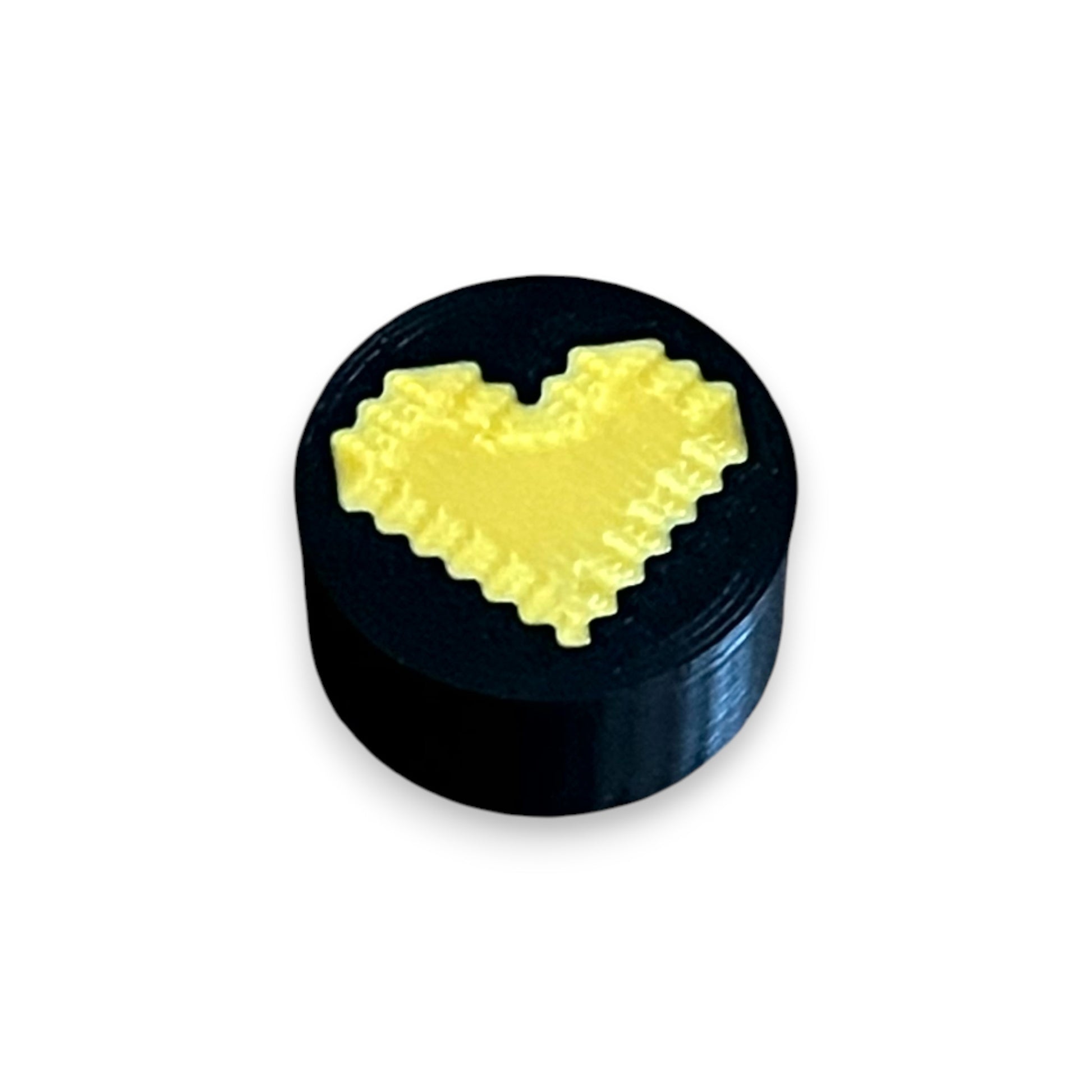 Black and Gold Heart Guitar Pedal Footswitch Toppers for 8.5mm / 10mm / 11mm Foot Switches. 3D printed by Cold Earth Industries, shown on a black topper with a gold heart icon on top, against a white background.