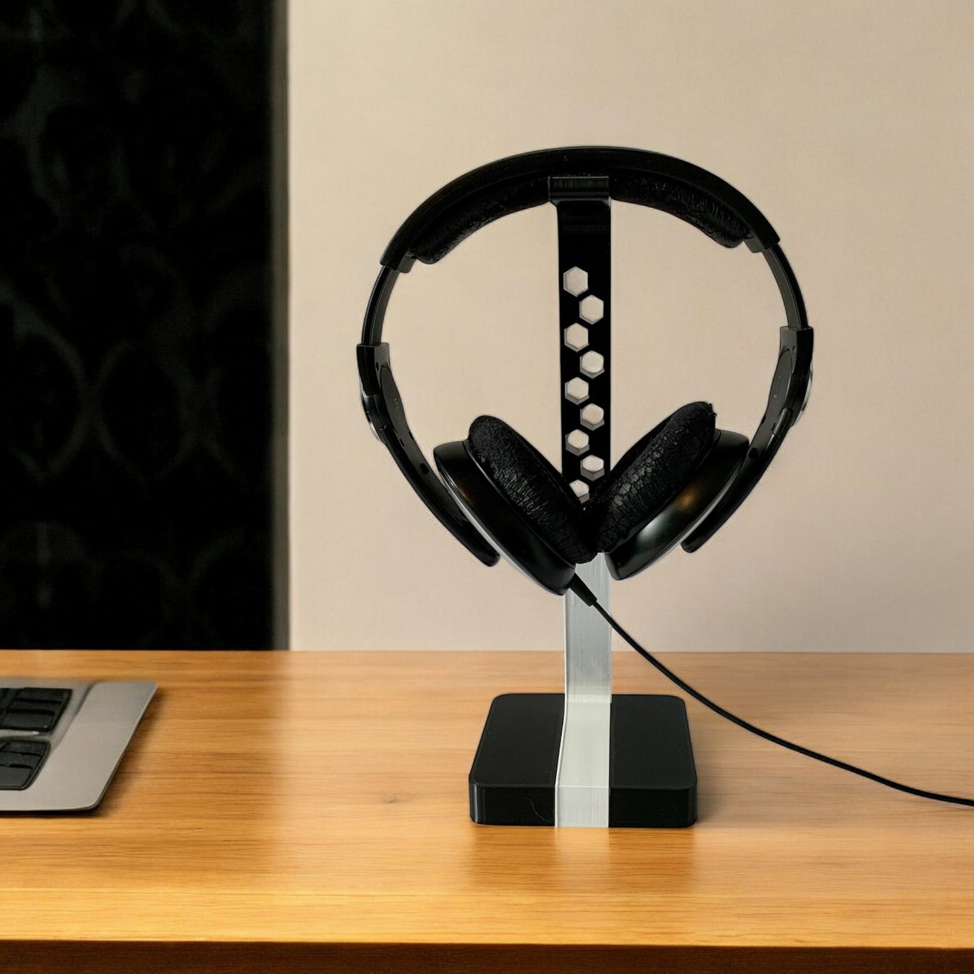 Headphone stand holding large studio headphones in a minimalist setup