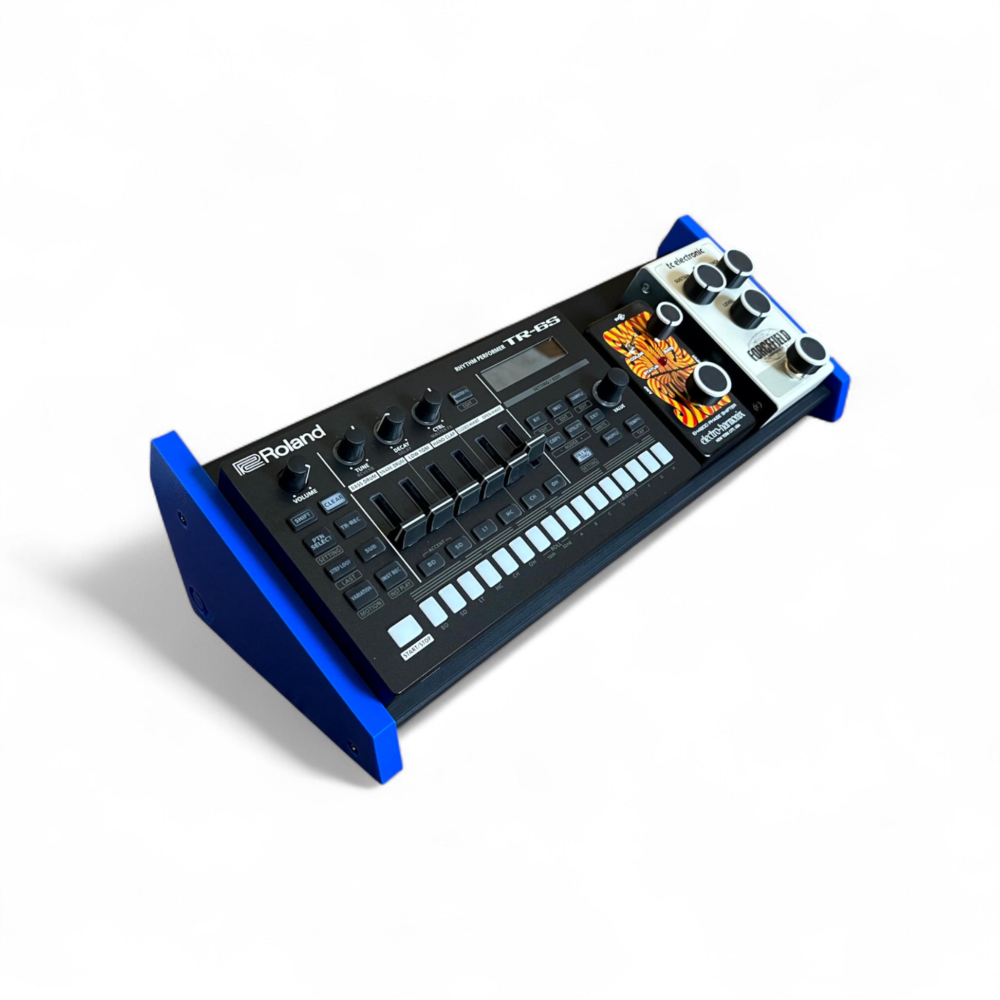 3D printed Desktop Pedalboard 400mm x 150mm 30 Degree Guitar Pedal & Synth Stand stand by Cold Earth Industries, shown in black with Blue sides on a white background. The stand is holding a Roland TR-6S Drum Machine and guitar pedals – custom desktop stands.
