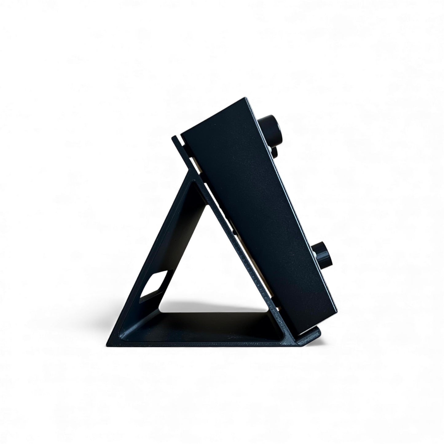 3D printed ElectroHarmonix Big Muff Pi Guitar Pedal 60 Degree stand by Cold Earth Industries, shown side view,  in black on a white background holding a ElectroHarmonix Big Muff Pi