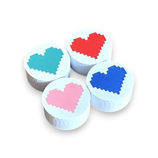 Guitar Pedal Footswitch Topper for 8.5mm / 10mm / 11mm Foot Switch. 3D printed Heart Design on White Toppers with a Green, Red, Pink and Blue heart by Cold Earth Industries, shown on a white background.