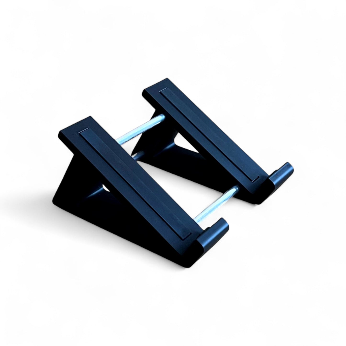 A 3D printed 30 degree black guitar pedal stand with rubber strips and recessed rubber feet, designed for the Line 6 HX Stomp Amp and Effects Processor.