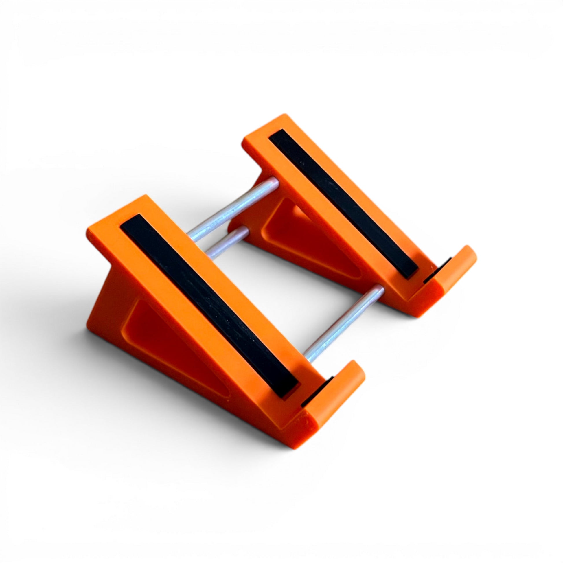 A 3D printed 30 degree orange guitar pedal stand with rubber strips and recessed rubber feet, designed for the Line 6 HX Stomp Amp and Effects Processor.