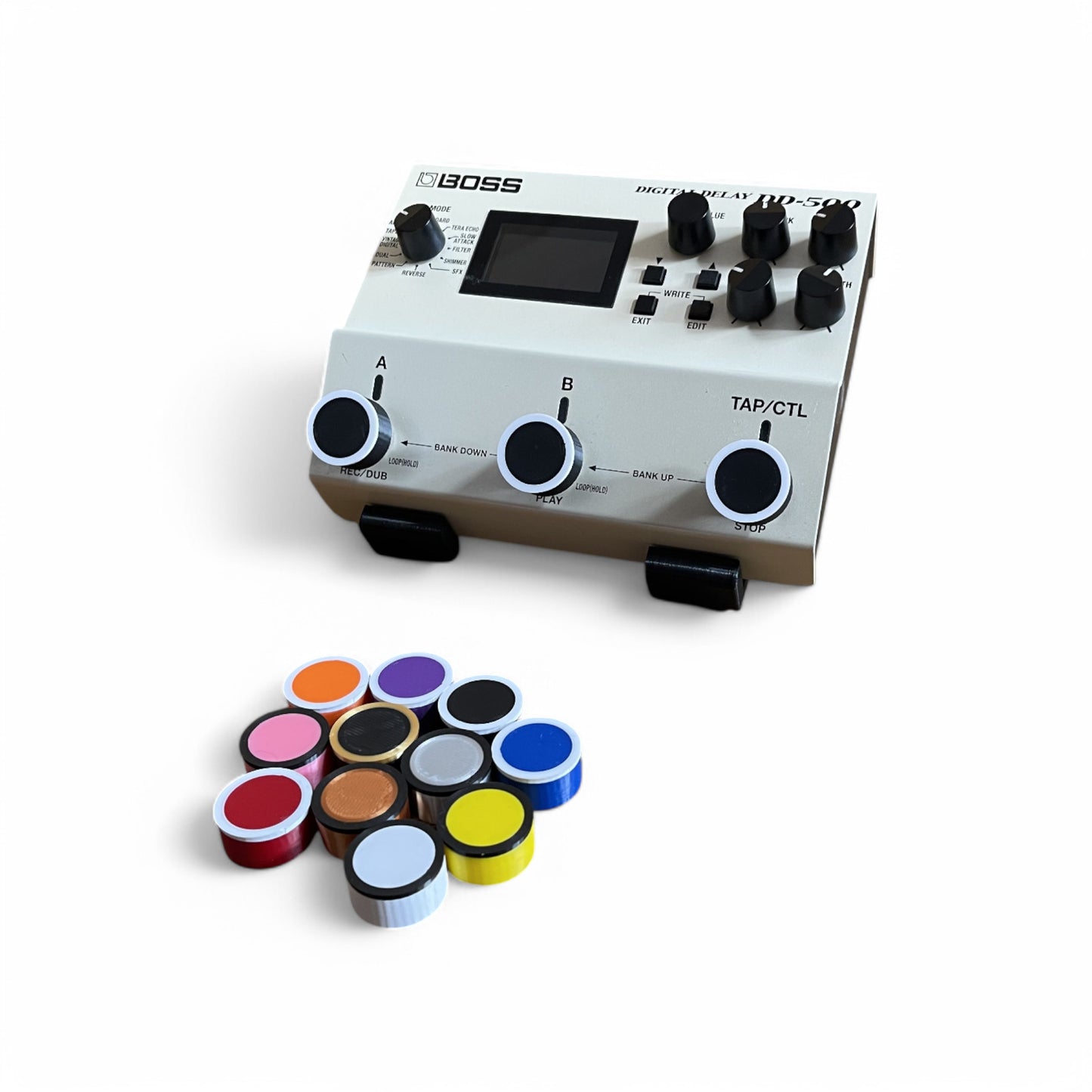 Boss digital delay effects pedal with black and white footswitch toppers and a selection of Guitar Pedal Footswitch Toppers for 11MM Foot Switch. 3D printed Ring Design by Cold Earth Industries, shown on a white background